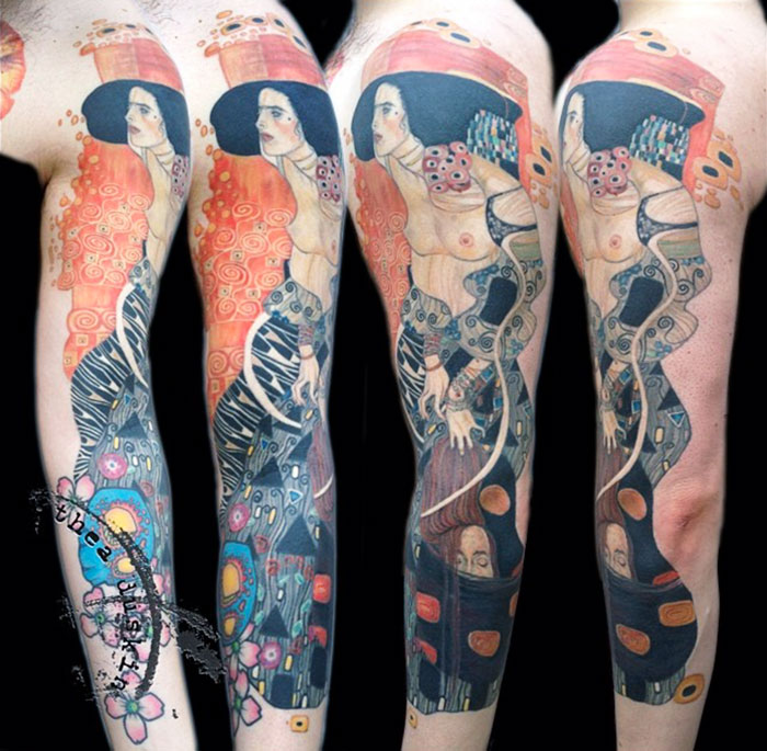 Gustav Klimt tattoo sleeve featuring vibrant colors and intricate designs on an arm.