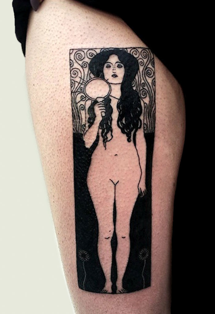 Gustav Klimt tattoo on thigh depicting a stylized, artistic figure holding a mirror in a detailed, decorative design.