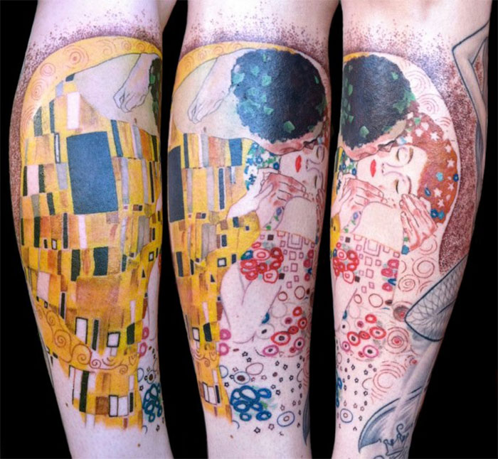 Gustav Klimt tattoo featuring "The Kiss" in vibrant colors on a forearm, showcasing artistic style.