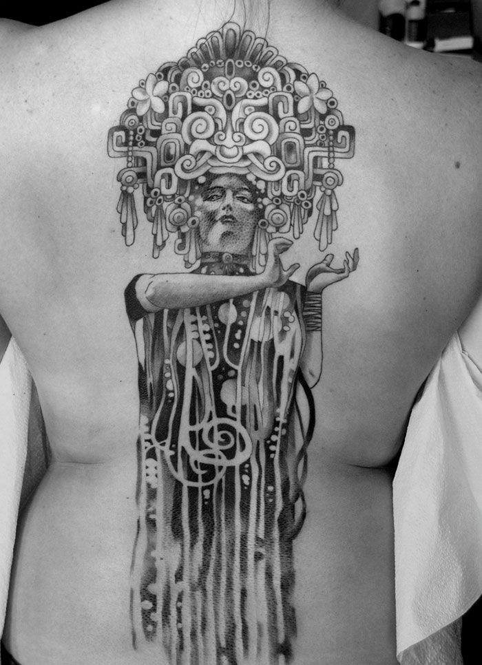 Tattoo inspired by Gustav Klimt on a person's back, featuring intricate patterns and artistic design.