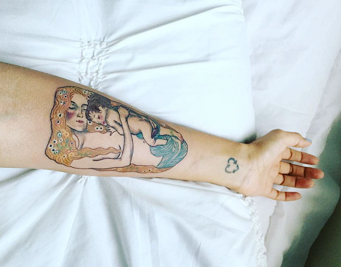 Gustav Klimt-inspired tattoo on forearm, depicting a mother and child, showcasing artistic design.