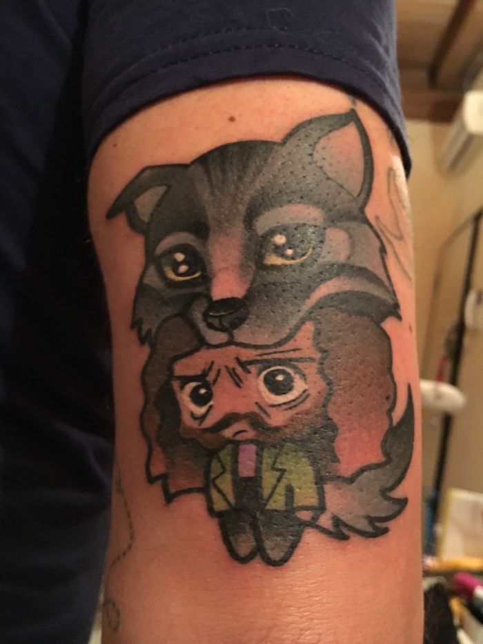Arm with a subtle Harry Potter tattoo featuring a wolf and a small cartoon character in wizard robes.
