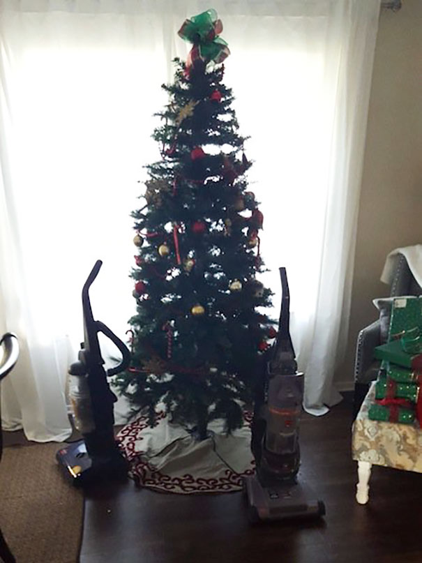 Christmas tree protected from pets using two vacuum cleaners.