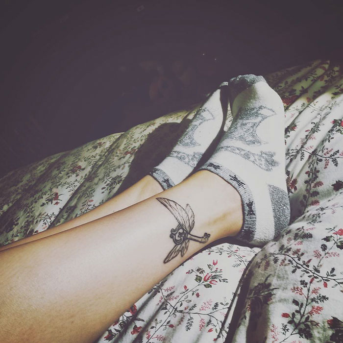 Subtle Harry Potter tattoo of a Golden Snitch on a person's leg.