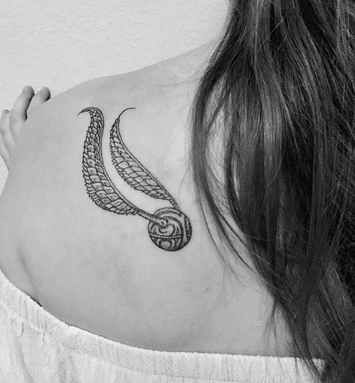 Golden Snitch tattoo on shoulder, showcasing subtle Harry Potter-themed ink for true fans.