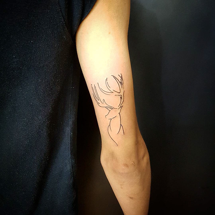 Minimalist Harry Potter tattoo of a stag on an arm, a subtle design for true fans.