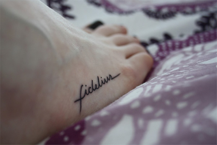 "Subtle Harry Potter tattoo of 'fidelis' on foot, showcasing minimalistic style for dedicated fans."