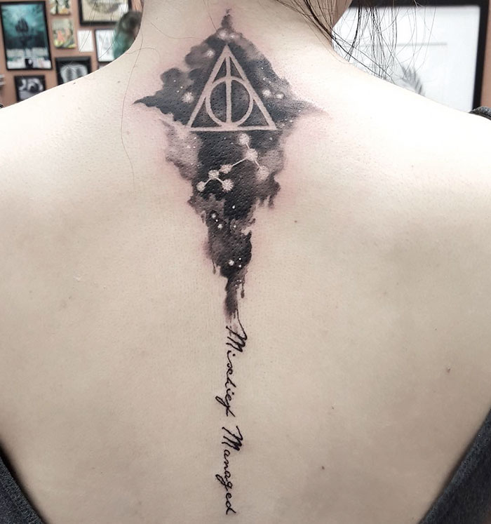 Subtle Harry Potter tattoo of the Deathly Hallows symbol and "Mischief Managed" text on the back.