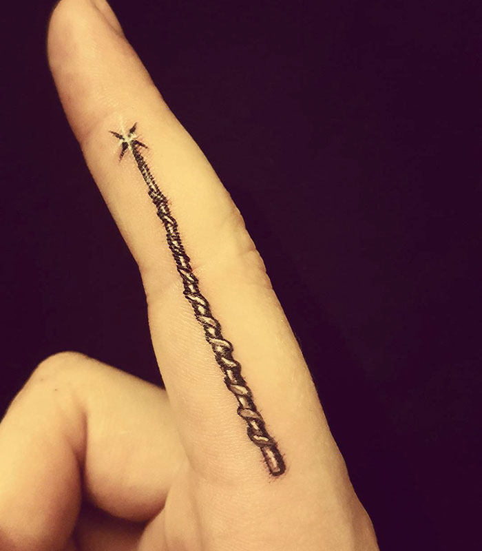 Subtle Harry Potter tattoo of a wand design on a finger.