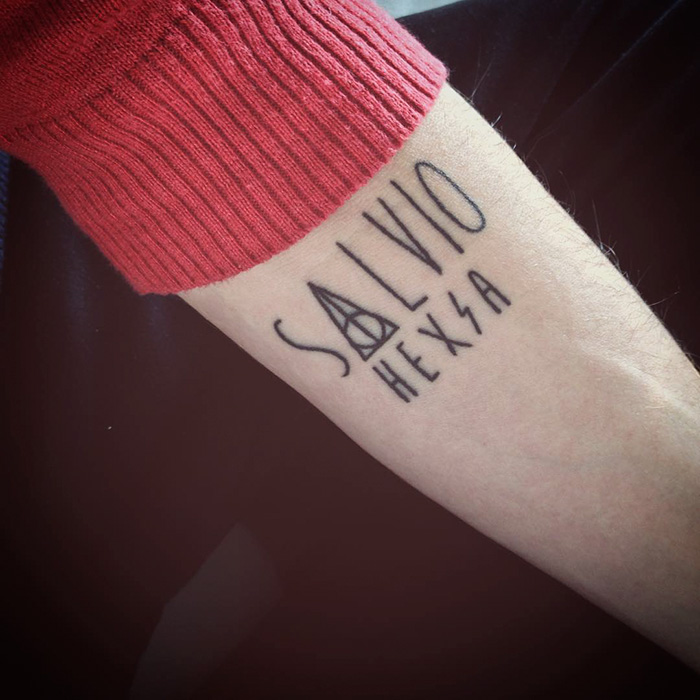 Harry Potter tattoo featuring the phrase "Salvio Hexia" with the Deathly Hallows symbol on an arm.