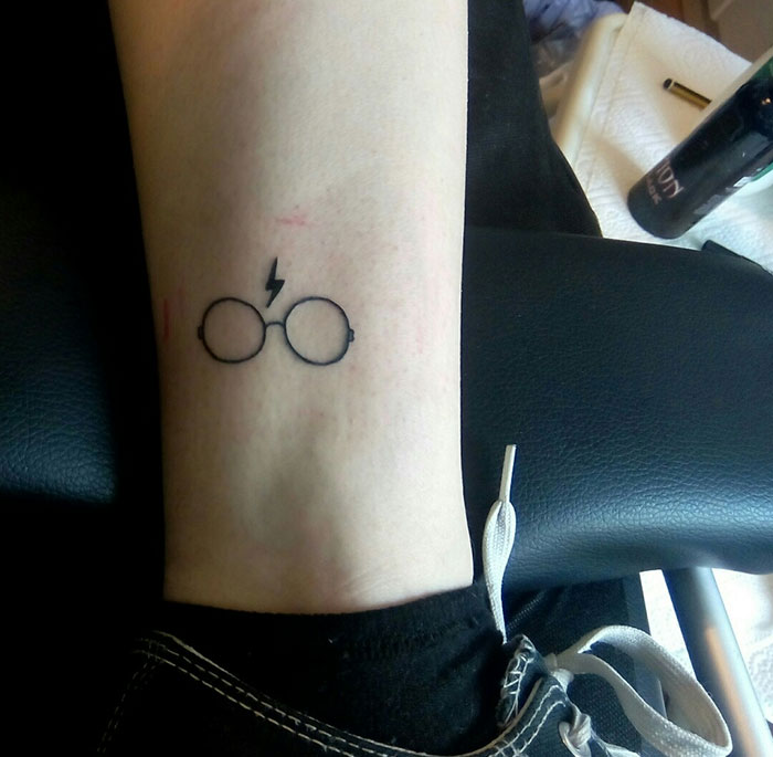 Harry Potter subtle tattoo of glasses and lightning bolt on arm.