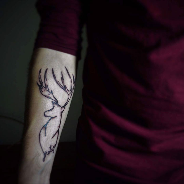 Subtle Harry Potter stag tattoo on forearm, representing a Patronus, inked in minimalist style.