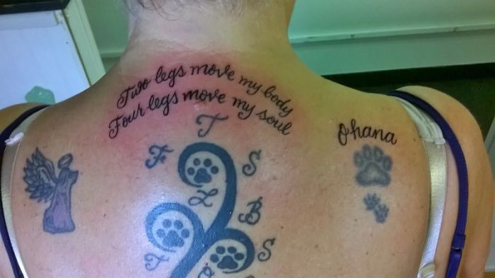 Dog tattoo ideas featuring paw prints and inspirational quotes on a person's back.
