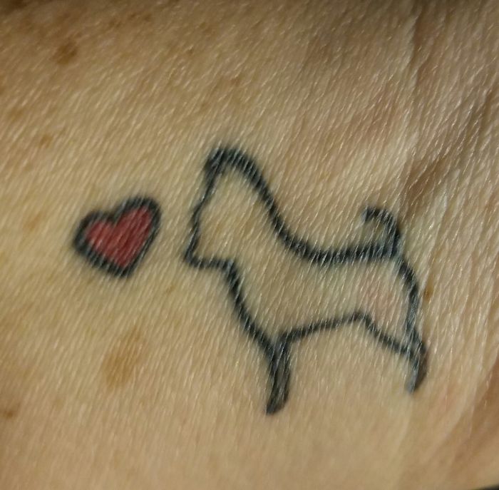 Simple dog tattoo with a heart symbol on skin.