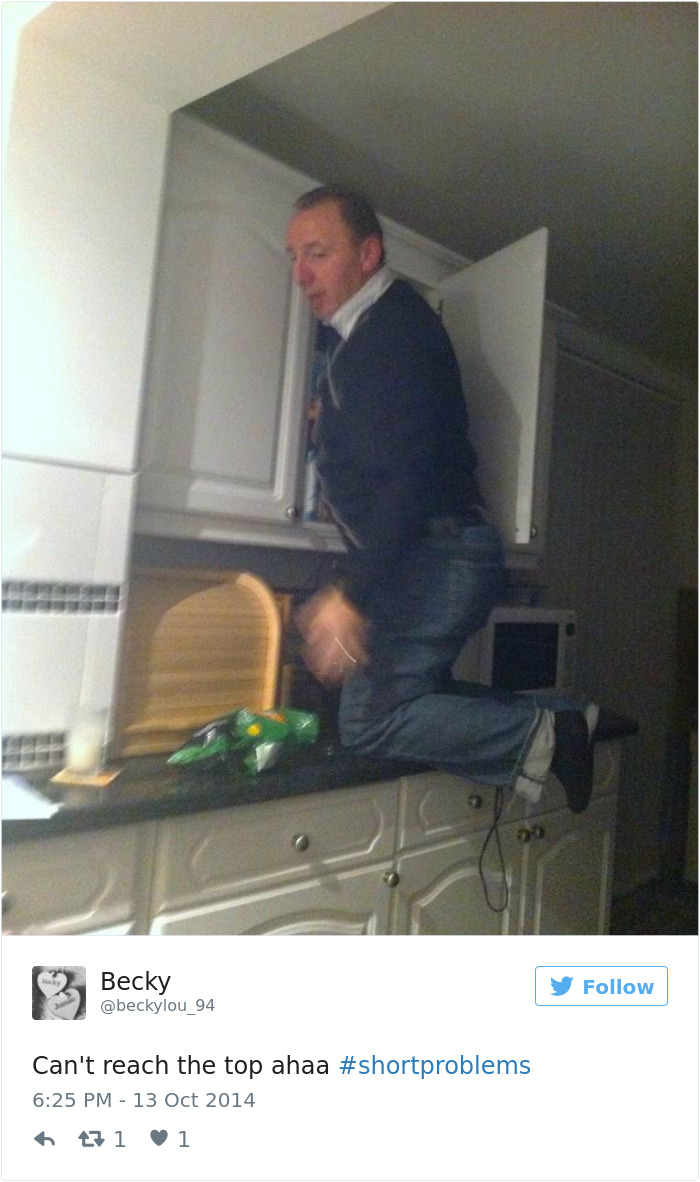 Person kneeling on a kitchen counter to reach a high shelf, illustrating short people problems.