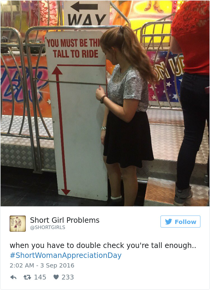 Woman checking height at amusement park, illustrating short people problems with "You Must Be This Tall To Ride" sign.
