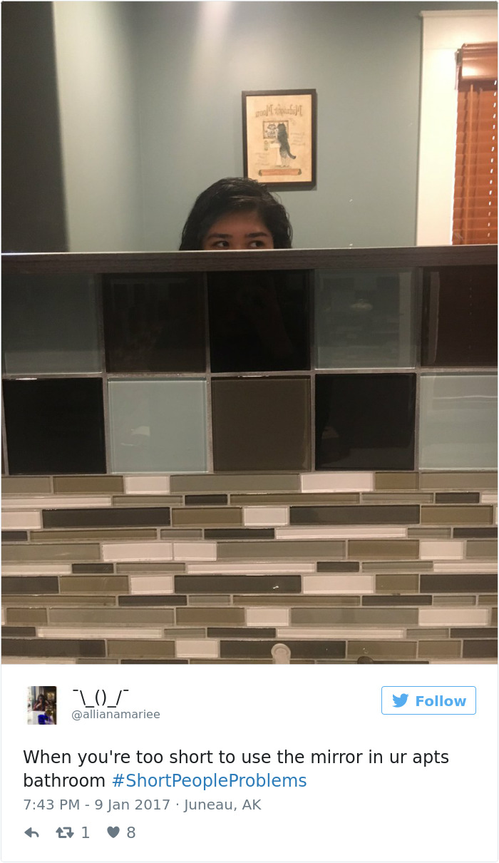 Short person struggling to see in bathroom mirror, illustrating common short people problems.