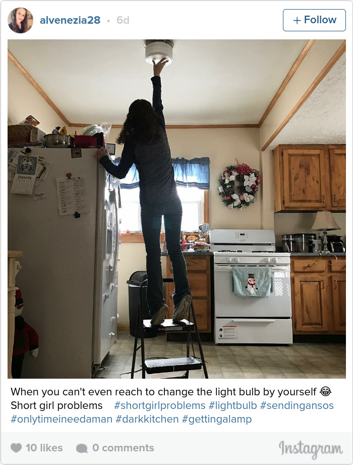 Person on step stool reaching up, displaying short people problems in a kitchen setting.