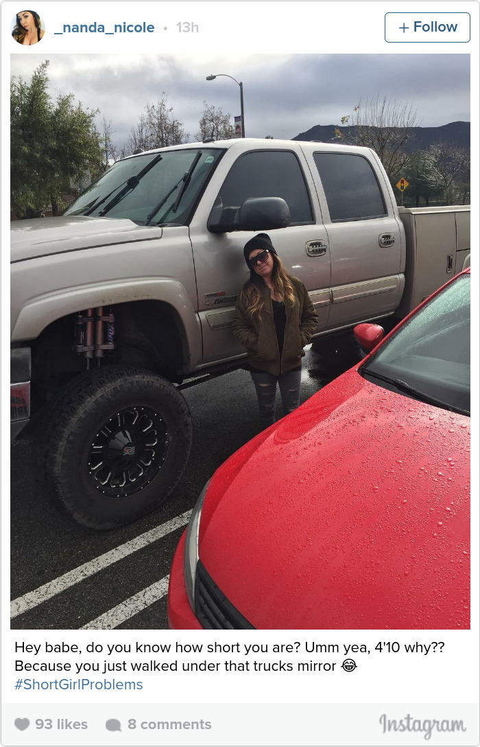 Woman standing beside a large truck, illustrating short people problems.