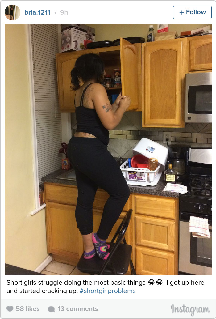 Person on a chair reaching into a kitchen cabinet, illustrating short people problems.