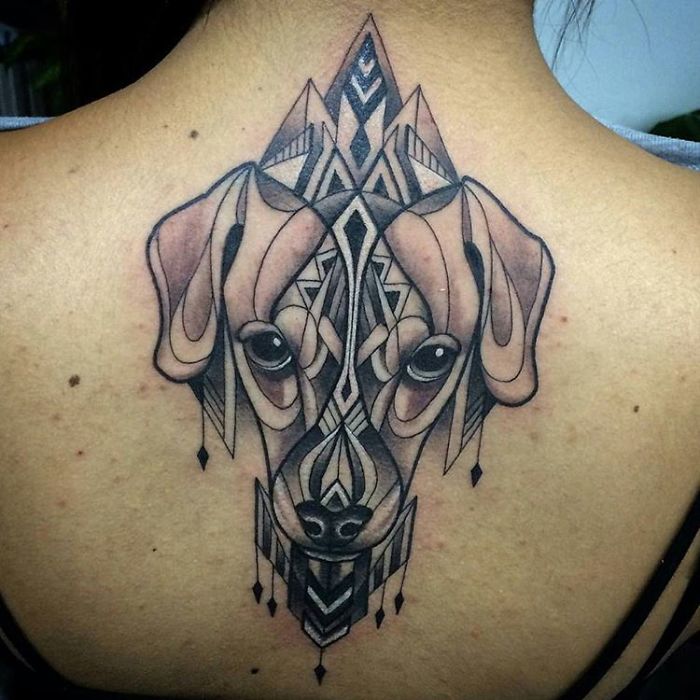 Geometric dog tattoo design on back, featuring intricate lines and patterns.