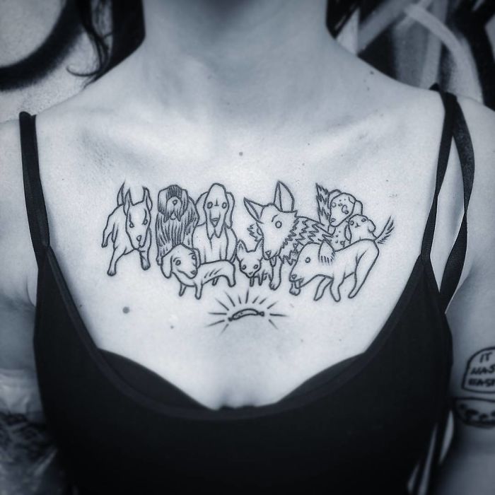 Minimalist dog tattoo on chest, featuring nine stylized cartoon dogs in black ink.