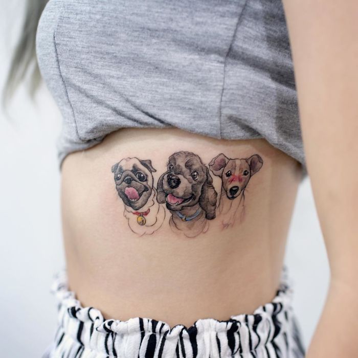 Dog tattoo featuring three different breeds on a person's side.