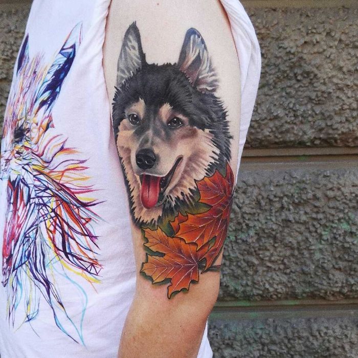 Dog tattoo on arm with realistic portrait, colorful leaves, and vibrant details.