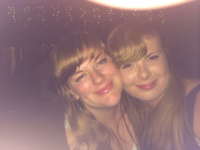 Two doppelgangers hugging and taking a selfie at the pub 