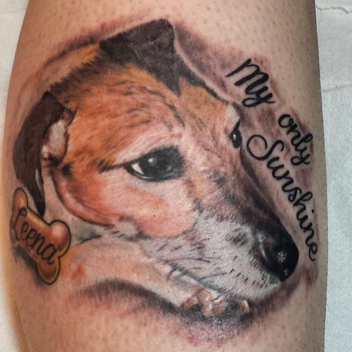 Realistic dog tattoo with "My only sunshine" text and bone tag with "Lena" written on it.