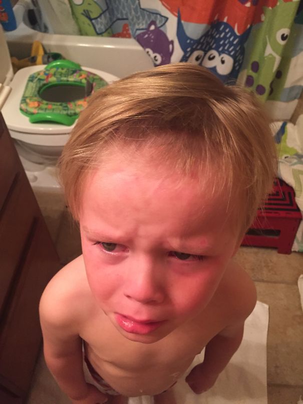 Child with self-cut hair looking upset in a bathroom, showing regretful expression.