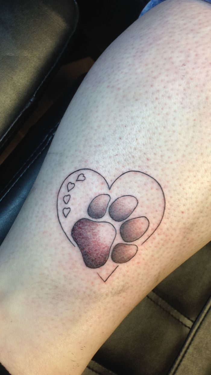 Paw print tattoo with a heart outline and small hearts, showcasing unique dog tattoo ideas.