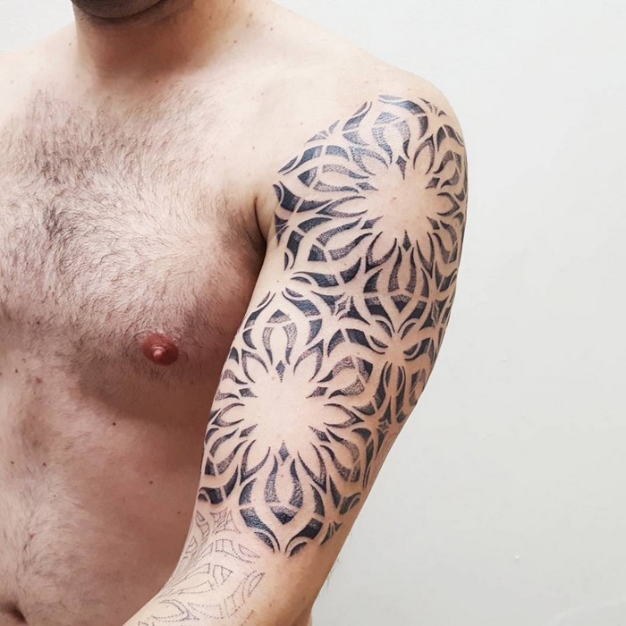 Amazonian tribal art tattoo on a man's upper arm by Brazilian artist Brian Gomes.