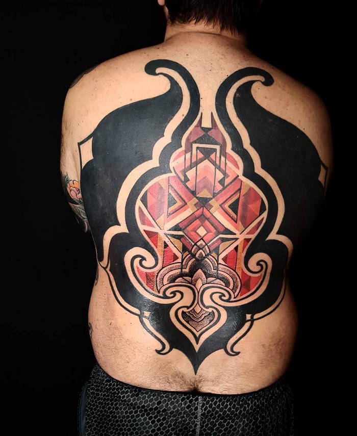 Back tattoo inspired by Amazonian tribal art, featuring bold geometric patterns by Brazilian artist.