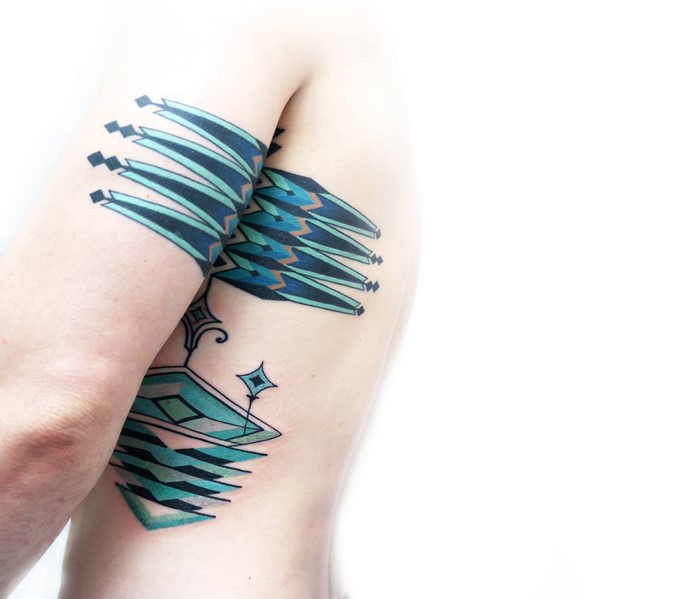 Amazonian tribal art tattoo in geometric patterns with teal and black ink on a person's arm and side.