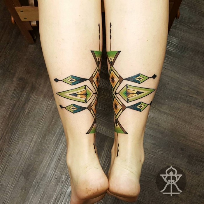 Amazonian tribal art-inspired tattoos on legs with geometric patterns by Brazilian artist.