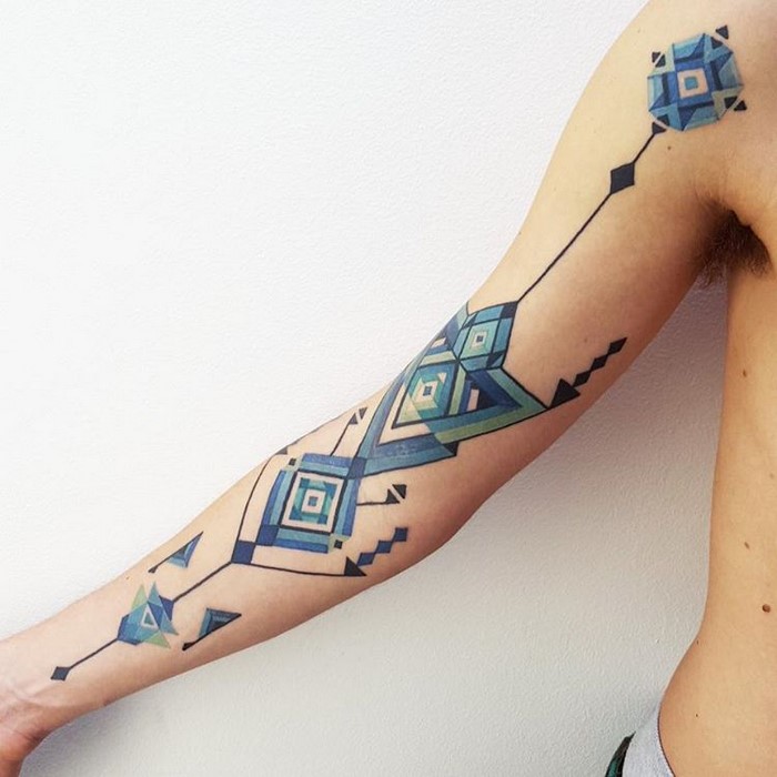 Tattoo featuring Amazonian tribal art on an arm, designed by Brazilian artist Brian Gomes.