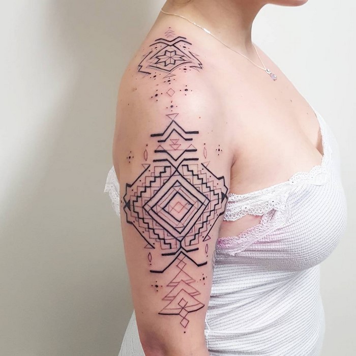 Amazonian tribal art tattoo on a woman's arm, featuring geometric patterns by Brazilian artist Brian Gomes.