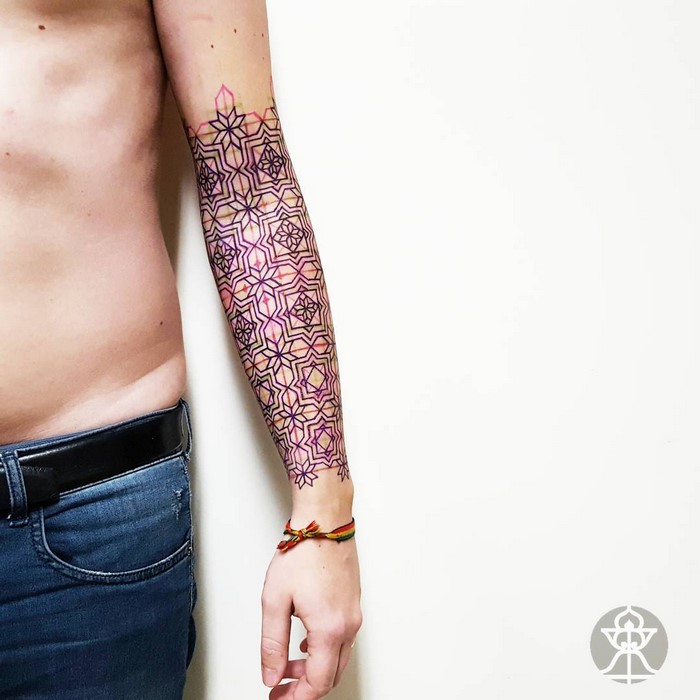 Amazonian tribal art tattoo by Brazilian artist Brian Gomes, featuring geometric patterns on an arm.