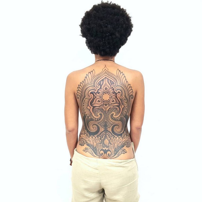 Back view of a person with an intricate Amazonian tribal tattoo by Brazilian artist Brian Gomes, featuring bold patterns.