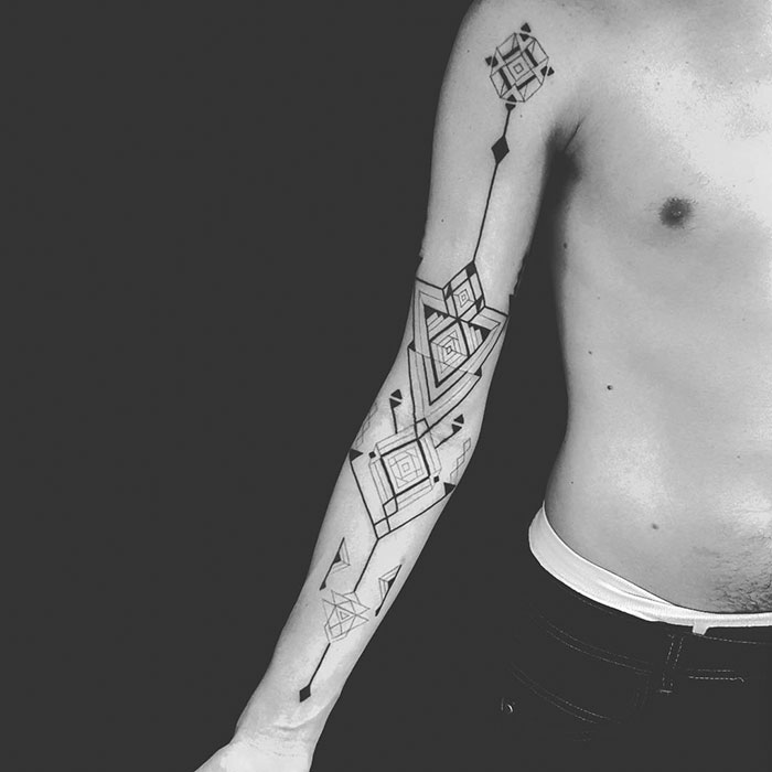 Geometric tattoo inspired by Amazonian tribal art by Brazilian artist Brian Gomes on a person's arm.