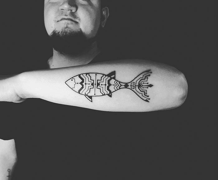 Brazilian-inspired Amazonian tribal tattoo of a fish on a man's forearm.