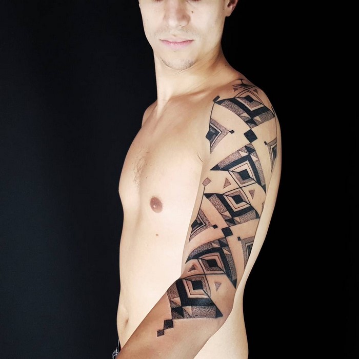 A man with Amazonian tribal art tattoo by Brazilian artist Brian Gomes on his arm.