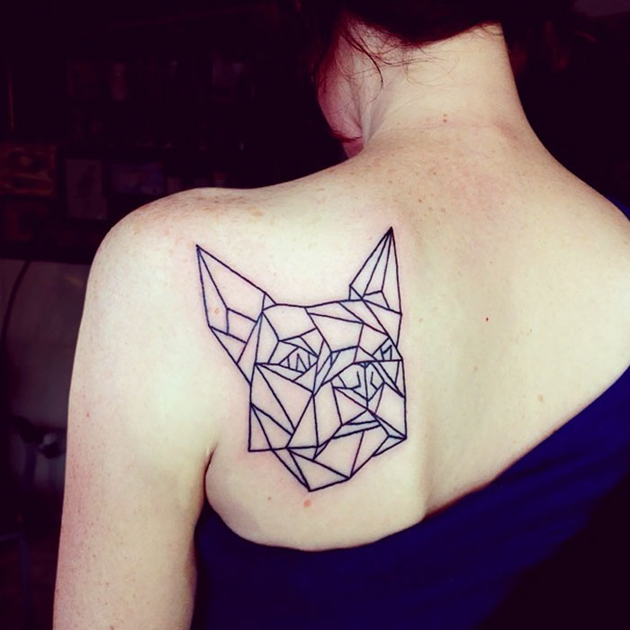 Geometric dog tattoo on a person's shoulder, showcasing a unique dog tattoo idea.