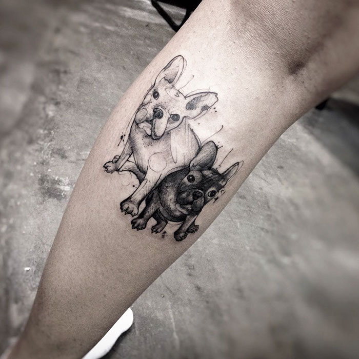 Dog tattoo featuring two French Bulldogs on a person's leg.