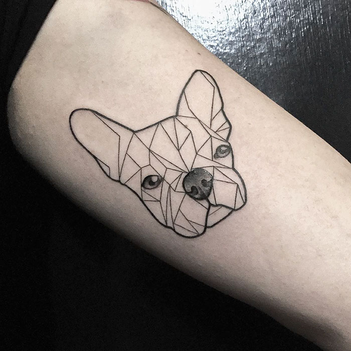 Geometric dog tattoo design on forearm, showcasing intricate line art of a canine face.