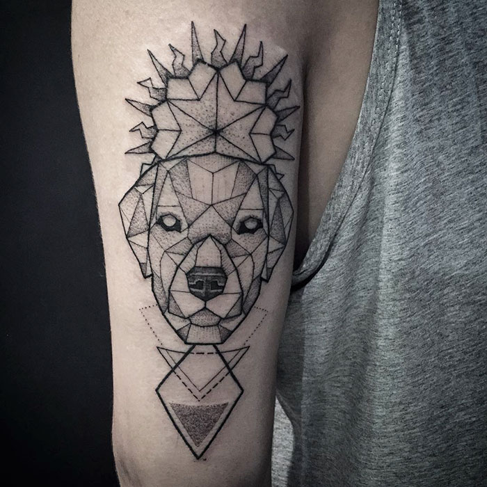 Geometric dog tattoo design with intricate lines on an arm.