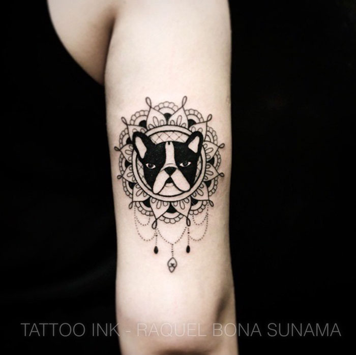 Ornate dog tattoo featuring a bulldog design with mandala elements on an arm.