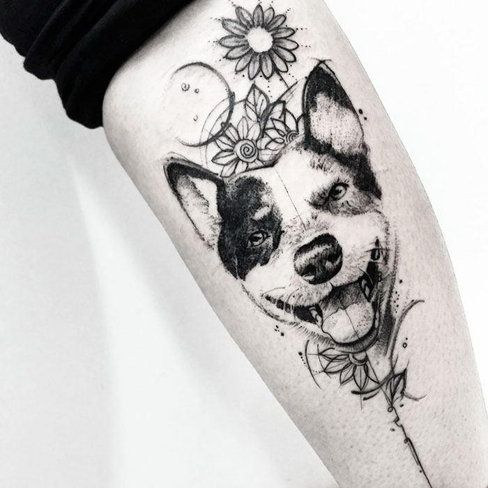 Dog tattoo featuring a realistic dog face with flowers, showcasing one of the best dog tattoo ideas.