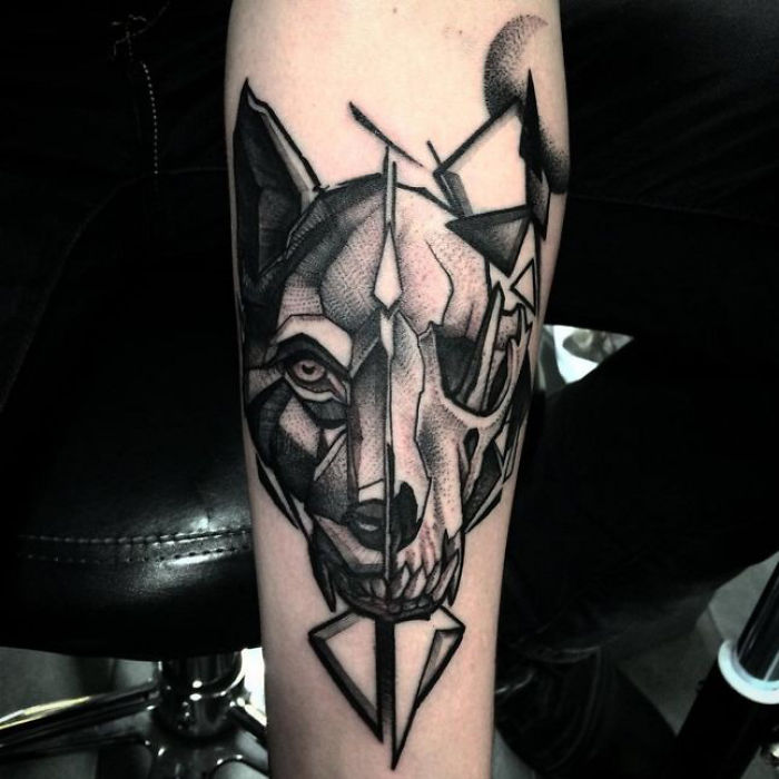 Geometric dog tattoo design on forearm, showcasing intricate patterns and shading.